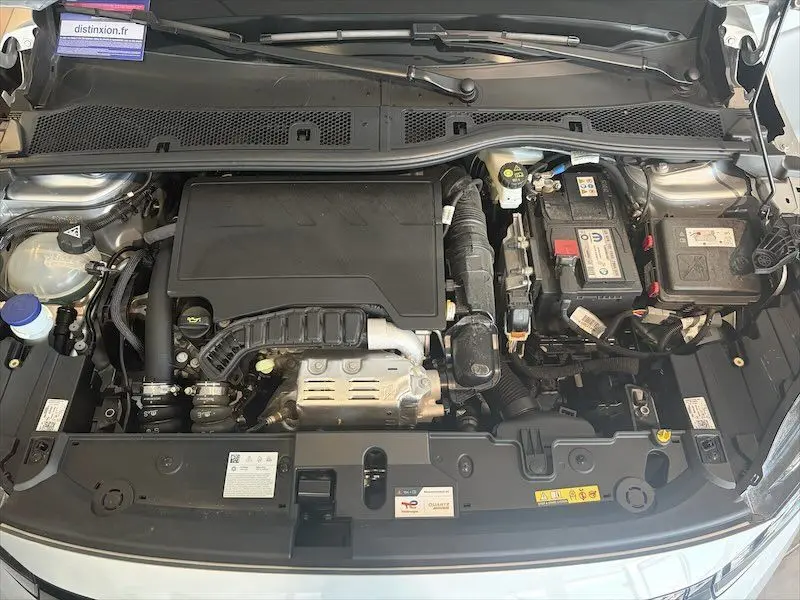 Vue plongeante sur le compartiment moteur gris de l'Opel Corsa 1.2 Turbo 100 Edition BVA8 essence 2025, avec batterie visible.