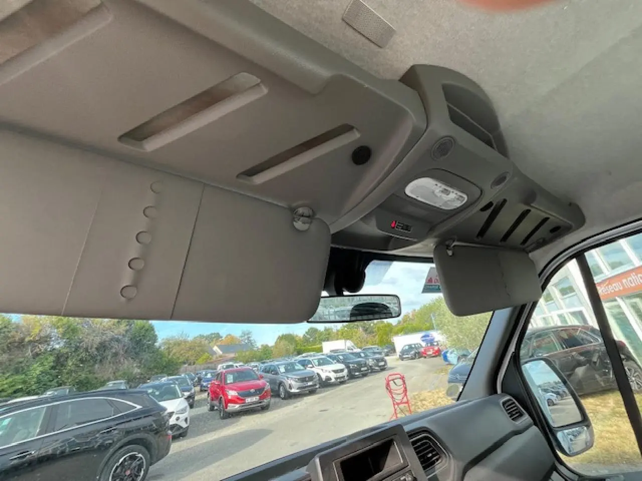 Vue intérieure du poste de conduite du Renault Master blanc 2024, montrant le pare-soleil et le tableau de bord côté droit.