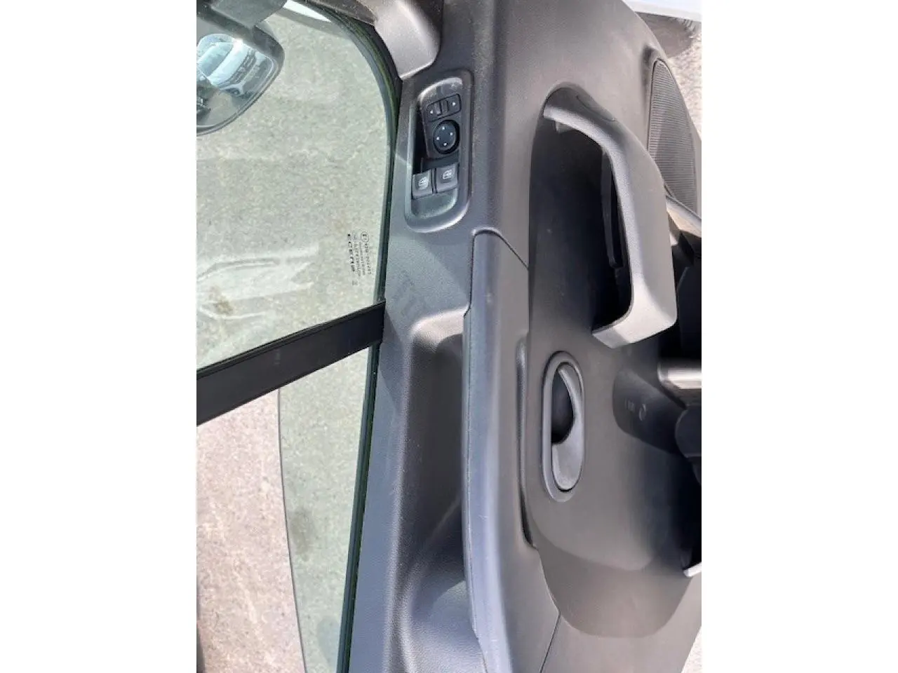 Détail de la porte côté conducteur du Renault Master blanc 2024, avec commandes électriques des vitres et poignée intégrée.