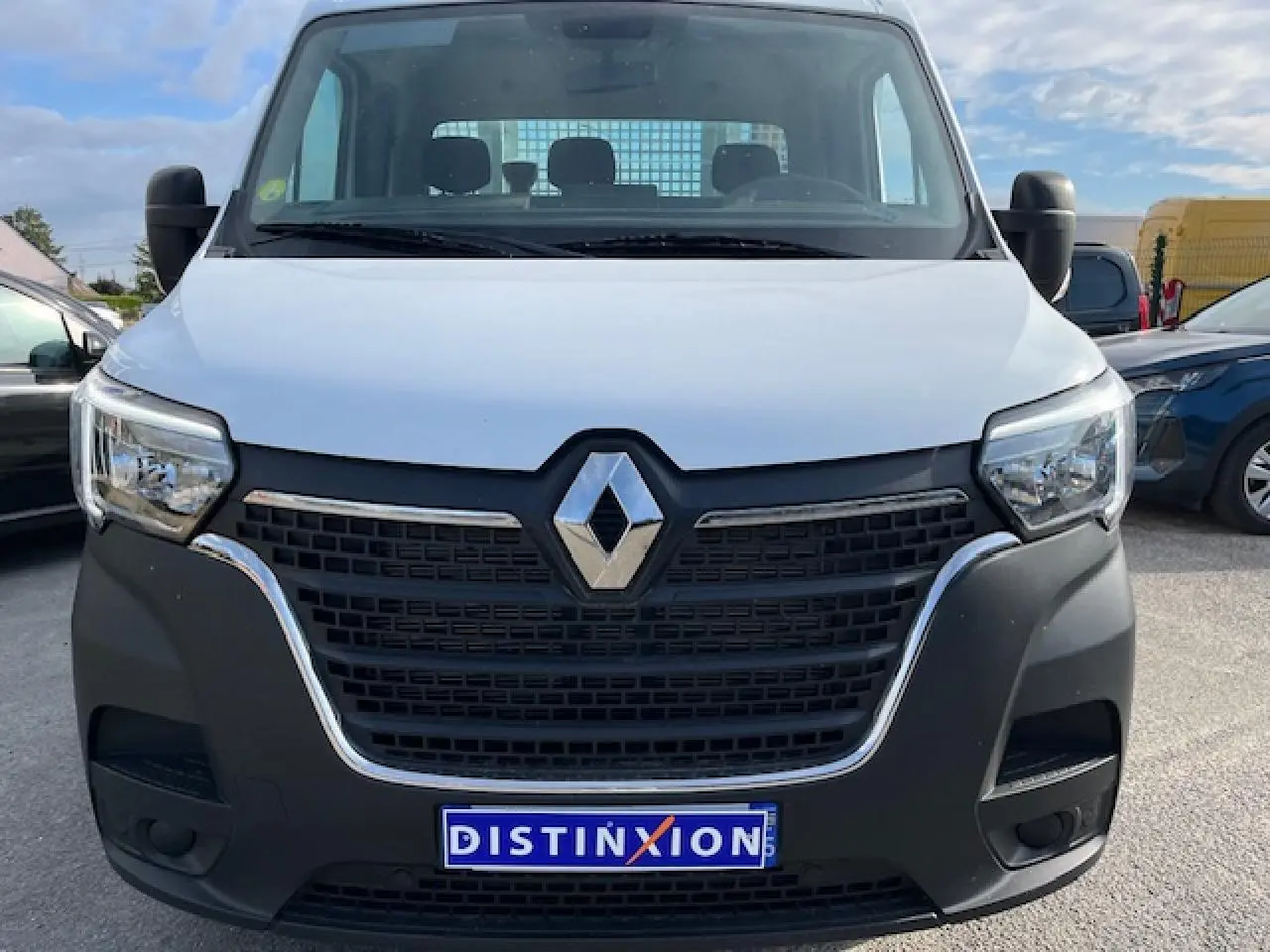 Vue frontale d’un Renault Master blanc 2024 avec calandre noire et benne basculante visible derrière la cabine.