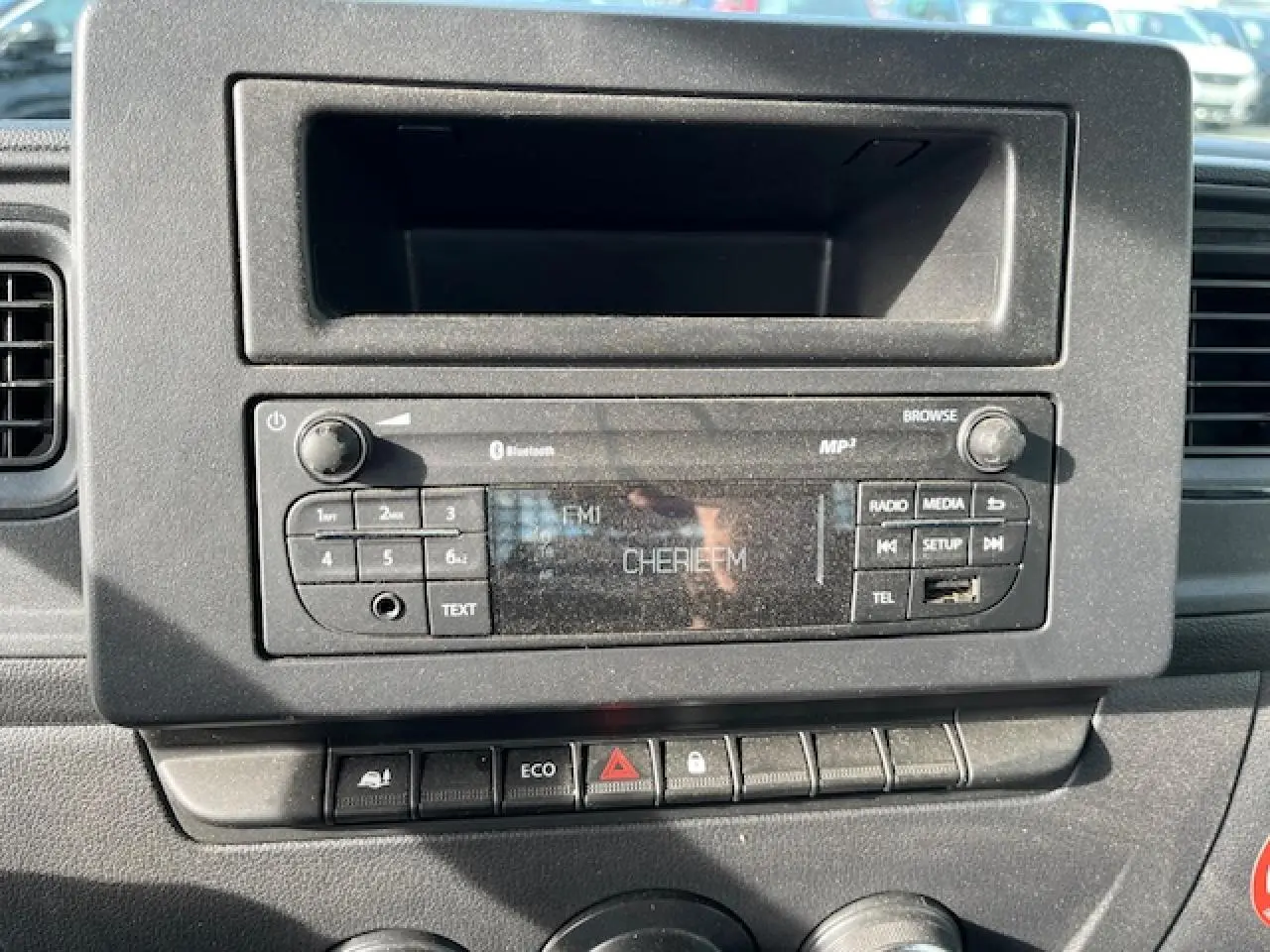 Vue rapprochée de la radio et des commandes centrales du tableau de bord du Renault Master blanc 2024, version benne basculante.
