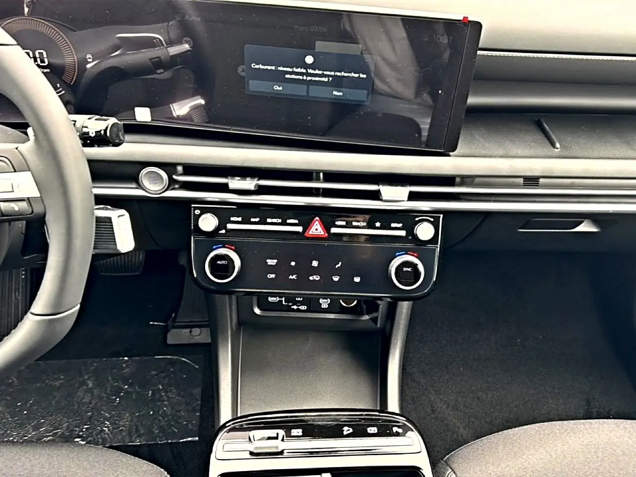 Vue intérieure du tableau de bord et console centrale du Hyundai Tucson 2026 avec écran tactile 12,3 pouces et commandes climatisation.
