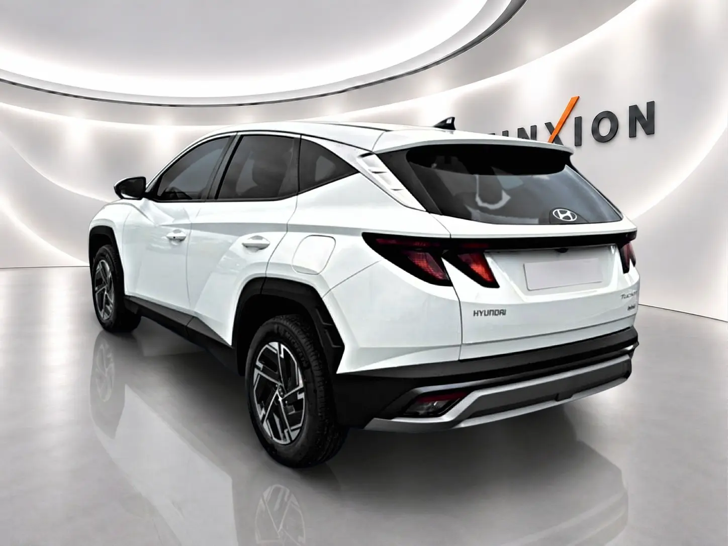 Vue 3/4 arrière droite du Hyundai Tucson blanc 2026 avec jantes alliage et feux arrière LED distinctifs.