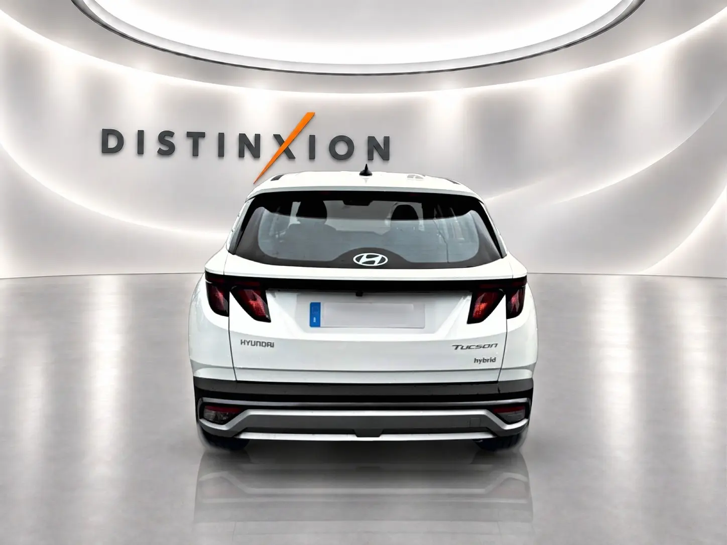 Vue arrière d'un Hyundai Tucson blanc hybride 2026, avec feux arrière LED et logo Hyundai visible.