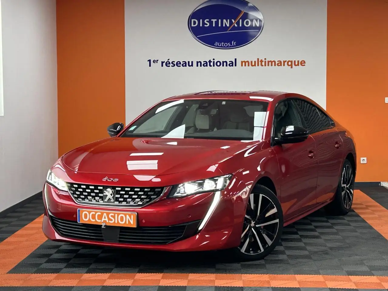Peugeot 508 Hybrid rouge clair vue 3/4 avant droit avec jantes alliage bi-ton et éclairage LED distinctif.