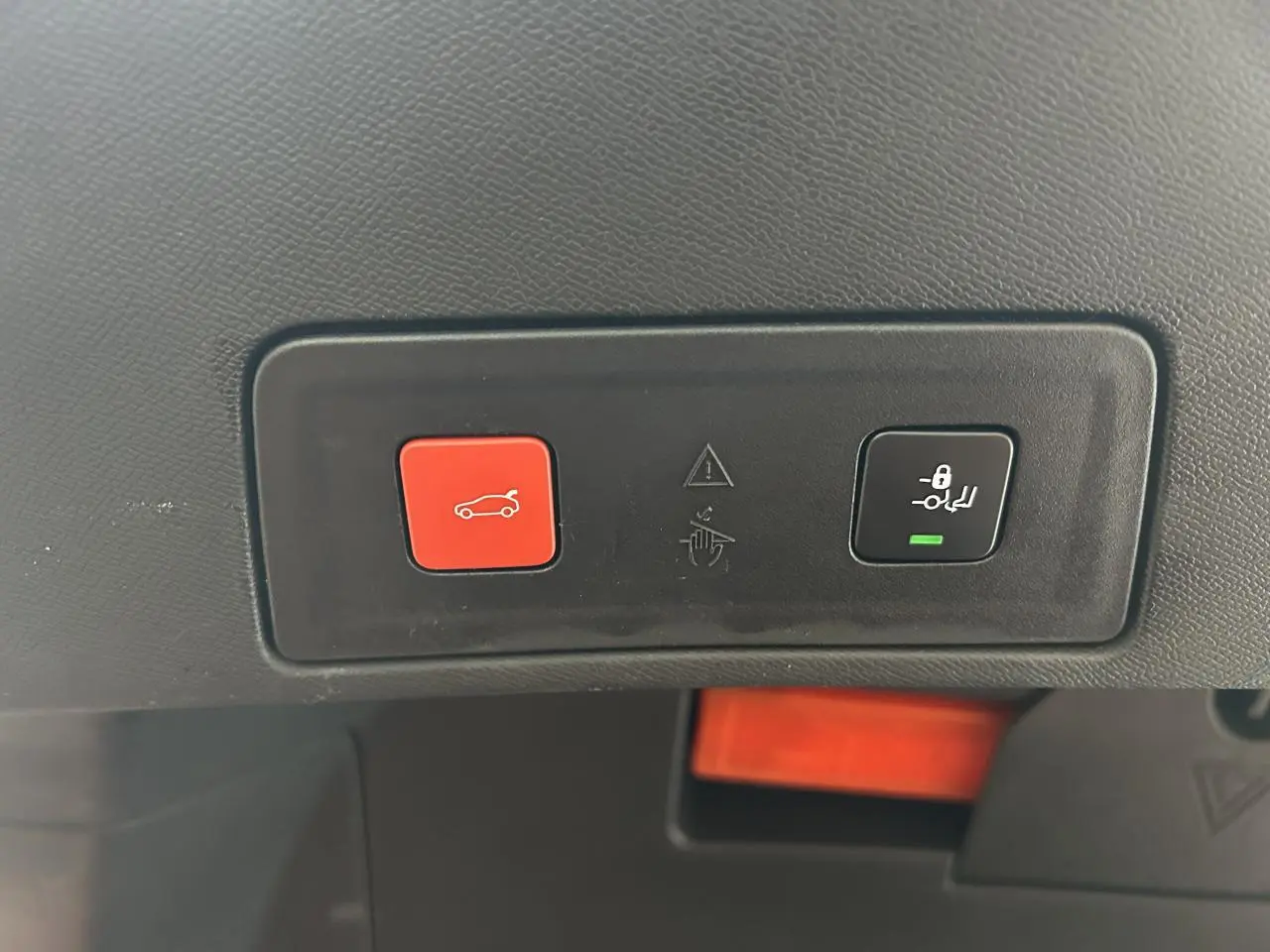 Boutons de commande du hayon électrique et verrouillage enfant sur la garniture intérieure d'une Peugeot 508 rouge clair.