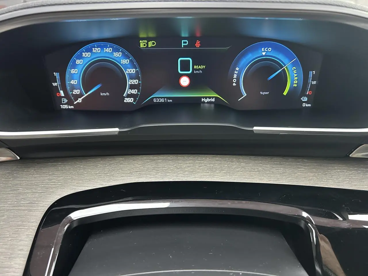 Tableau de bord numérique de la Peugeot 508 Hybrid 225, affichage vitesse et indicateurs énergie en bleu et vert.