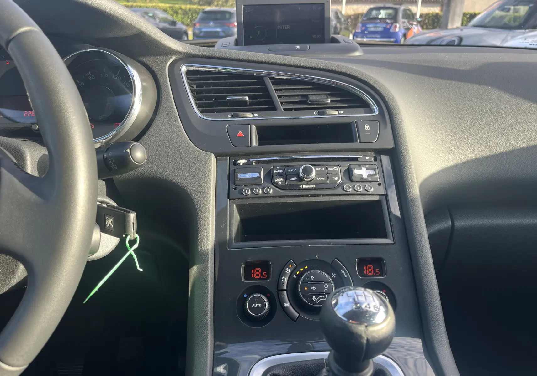 Intérieur de la Peugeot 5008 2013 vue centrale, tableau de bord noir avec GPS intégré et levier de vitesse manuel.