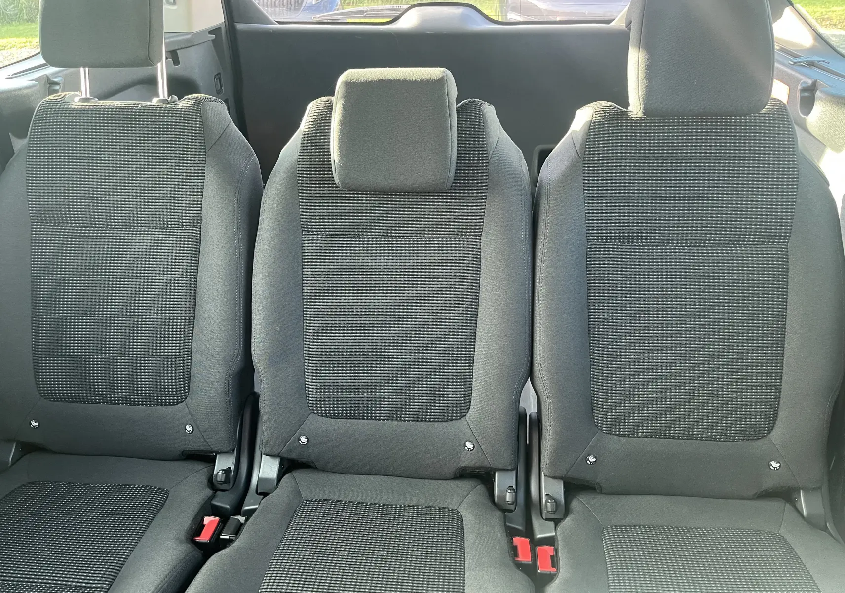 Vue rapprochée des trois sièges arrière gris foncé du Peugeot 5008 2013, avec appuie-têtes et ceintures visibles.