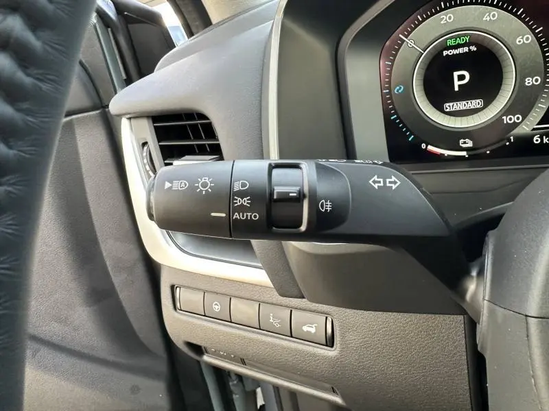 Gros plan sur le commodo gauche et le tableau de bord numérique du Nissan Qashqai Hybrid e-POWER 2025 en Gris Argile.