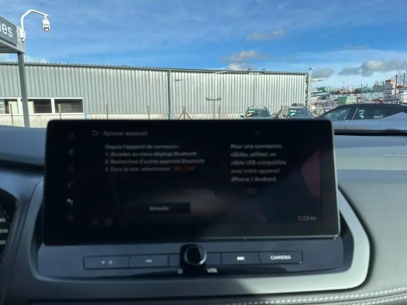 Vue intérieure du tableau de bord du Nissan Qashqai Hybrid e-POWER 2025, écran tactile central avec commandes sous-jacentes.