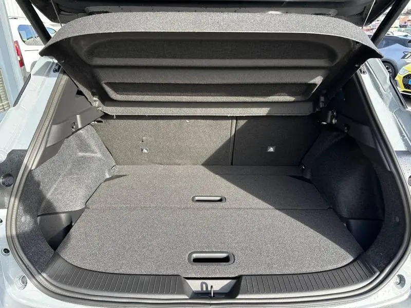 Coffre ouvert vu de l'arrière du Nissan Qashqai Hybrid e-POWER 2025 en Gris Argile, montrant l'espace de chargement plat.