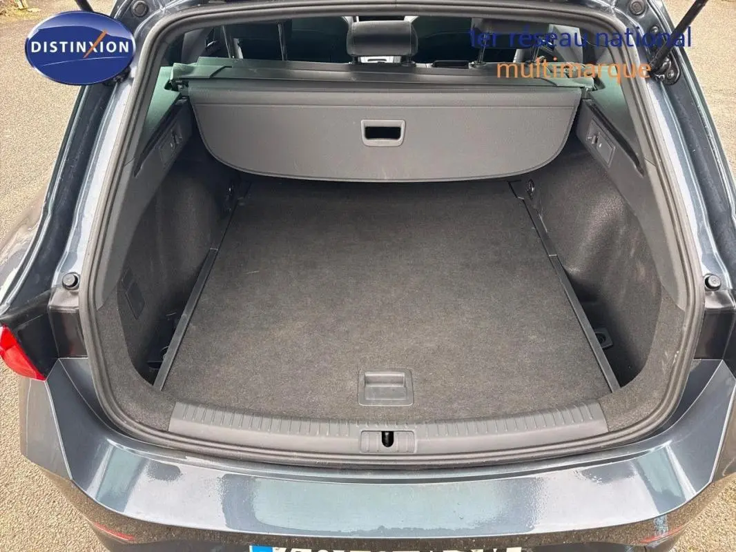Vue arrière du coffre ouvert d'une CUPRA Leon ST gris métallisé, montrant un espace de chargement propre et spacieux.