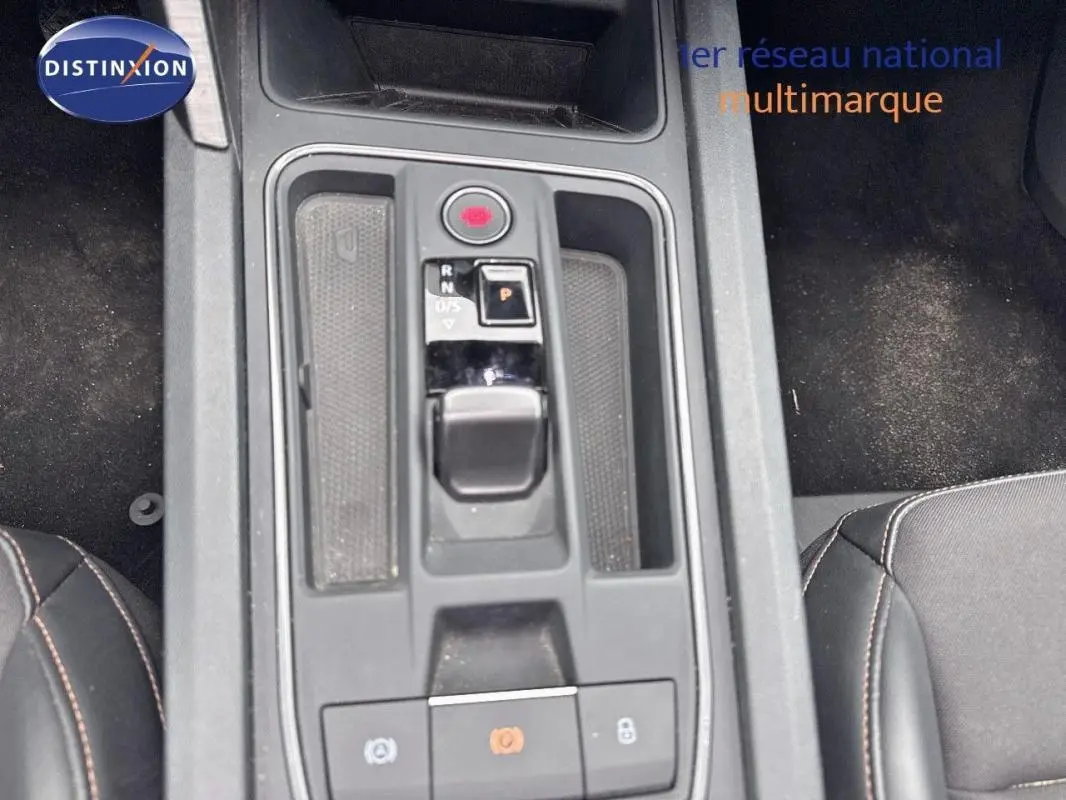 Vue plongeante sur la console centrale grise de la CUPRA Leon ST 2024 avec levier de boîte automatique et frein à main électronique.