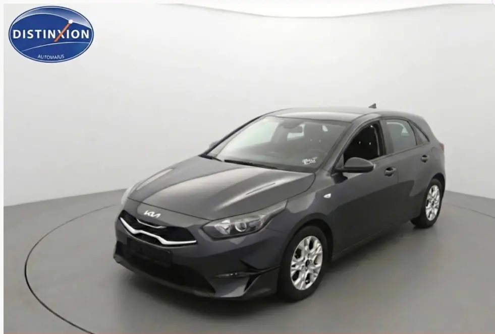 KIA CEE'D gris vue 3/4 avant droit dans studio, avec jantes 16 pouces et calandre moderne.