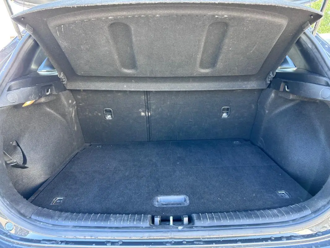 Coffre ouvert vu de l'arrière d'une KIA CEE'D gris 2022, montrant un espace de chargement propre et vide.
