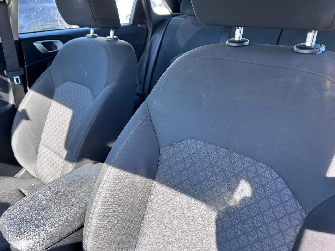 Gros plan sur les sièges avant gris de la KIA CEE'D 2022 avec accoudoir central et tissu à motifs géométriques.