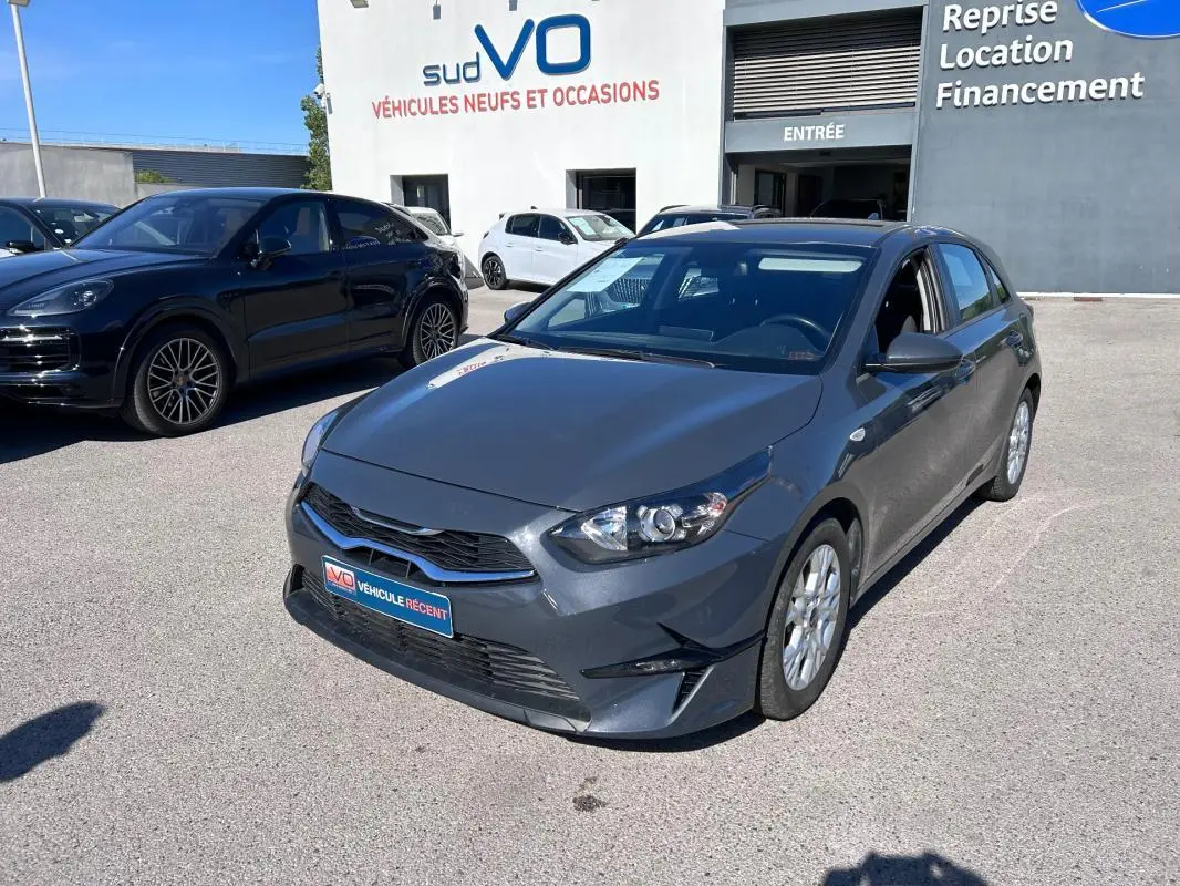 KIA CEE'D gris vue 3/4 avant droit, avec jantes 16 pouces et calandre noire brillante.