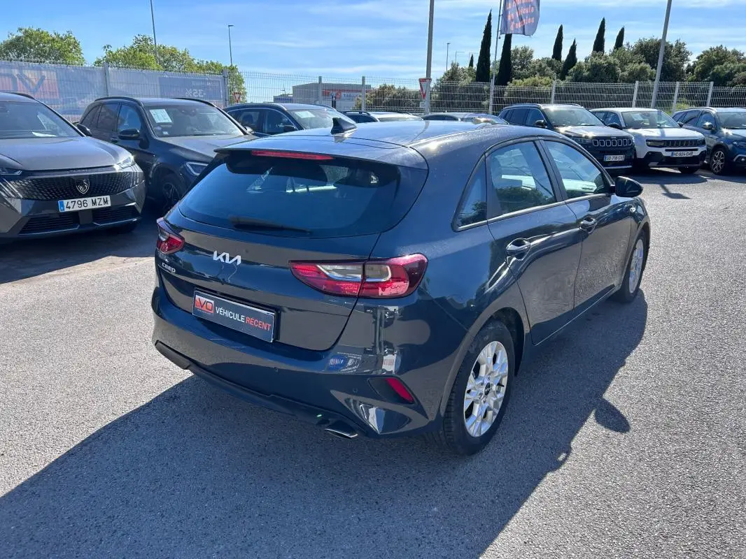 Vue 3/4 arrière droite d'une KIA CEE'D gris métallisé avec jantes 16 pouces, stationnée en extérieur au soleil.