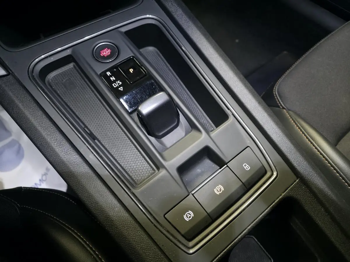 Vue rapprochée de la console centrale noire avec levier de vitesse automatique et boutons de commande du CUPRA Leon 2023.