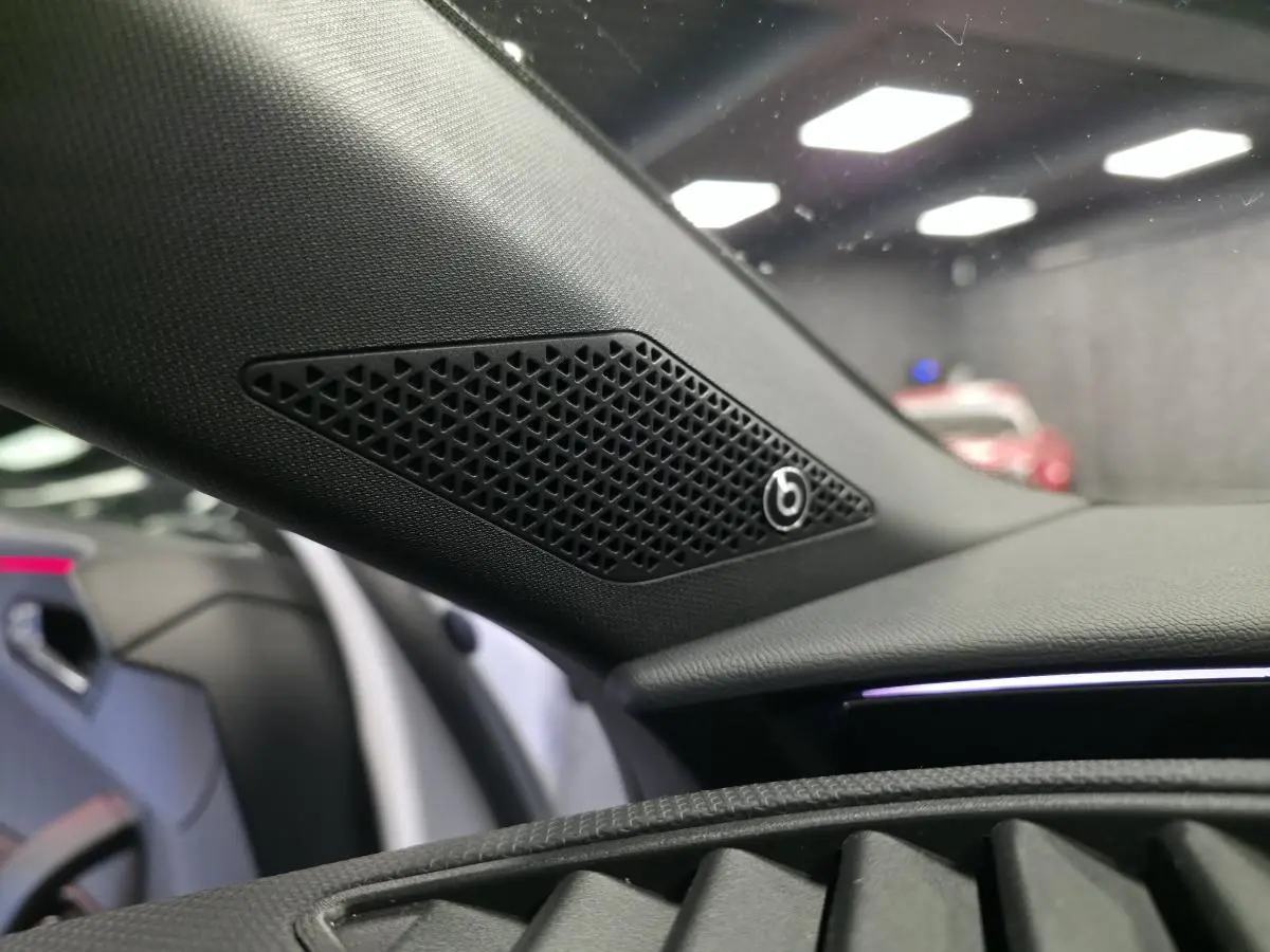 Gros plan sur le haut de la planche de bord côté gauche d’une CUPRA Leon blanche, avec haut-parleur Beats Audio intégré.
