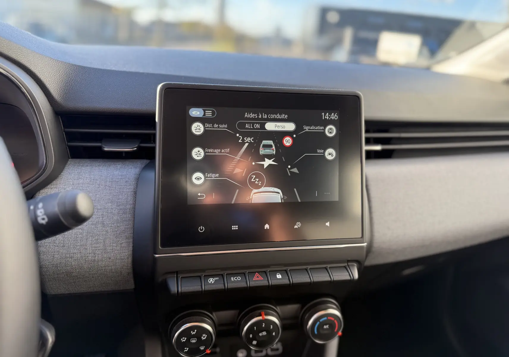 Vue rapprochée de la console centrale de la Renault Clio V gris schiste, avec écran tactile affichant aides à la conduite.