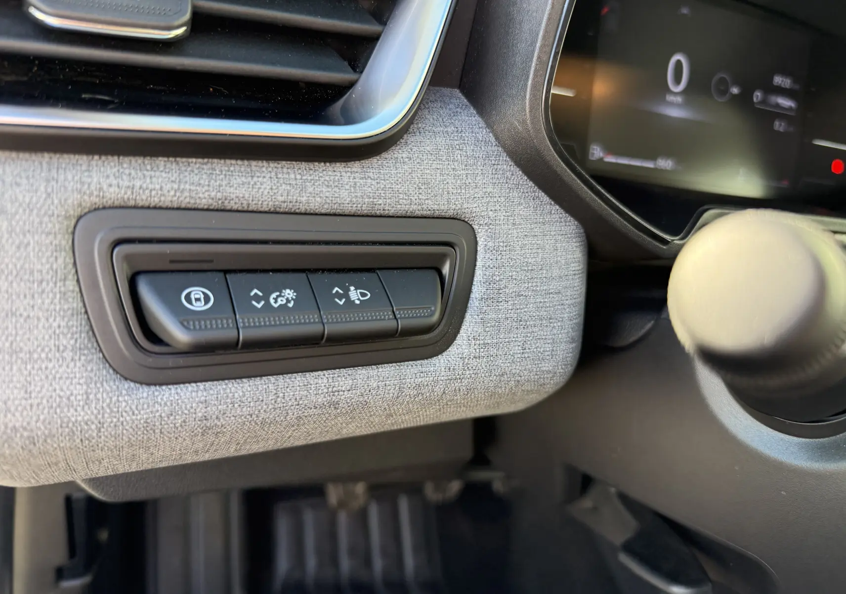 Détail des commandes d'éclairage et verrouillage sur tableau de bord tissu gris clair de Renault Clio V 2025.