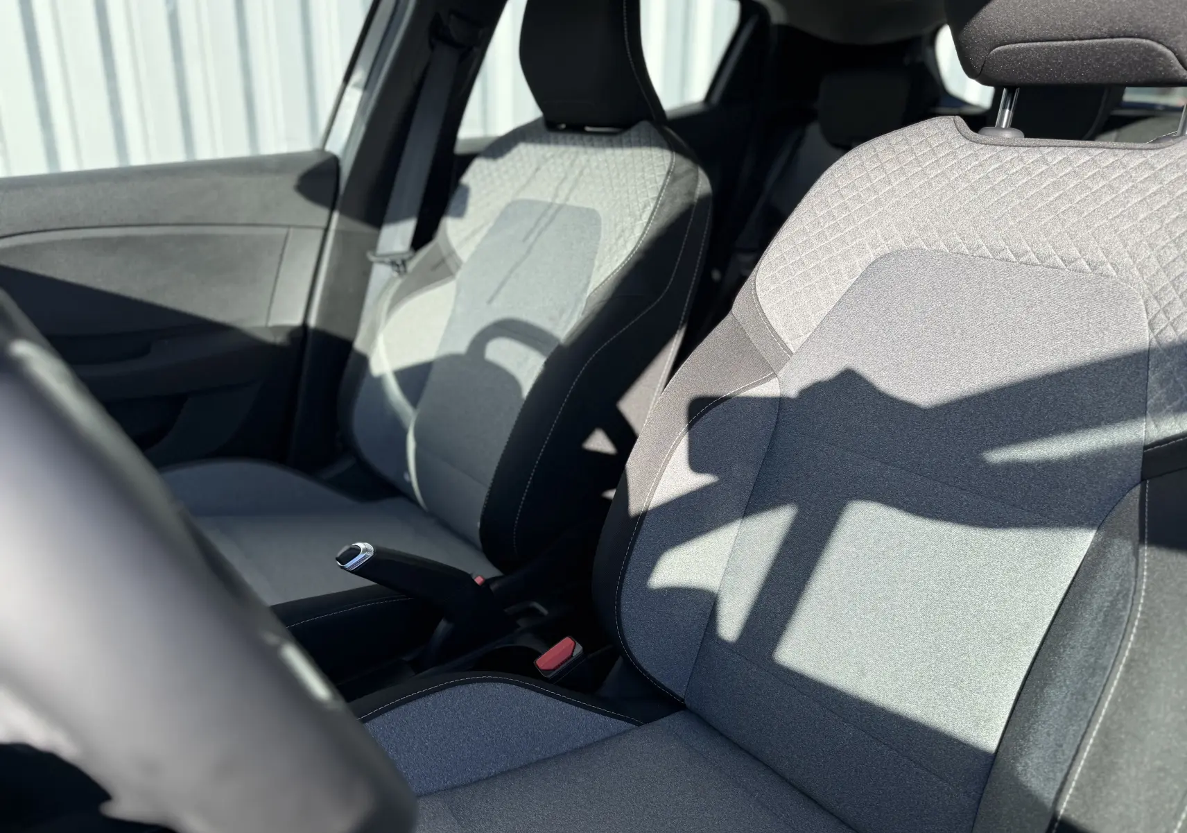 Gros plan sur les sièges avant gris clair et foncé de la Renault Clio V 1.5 dCi 100, vue côté conducteur.