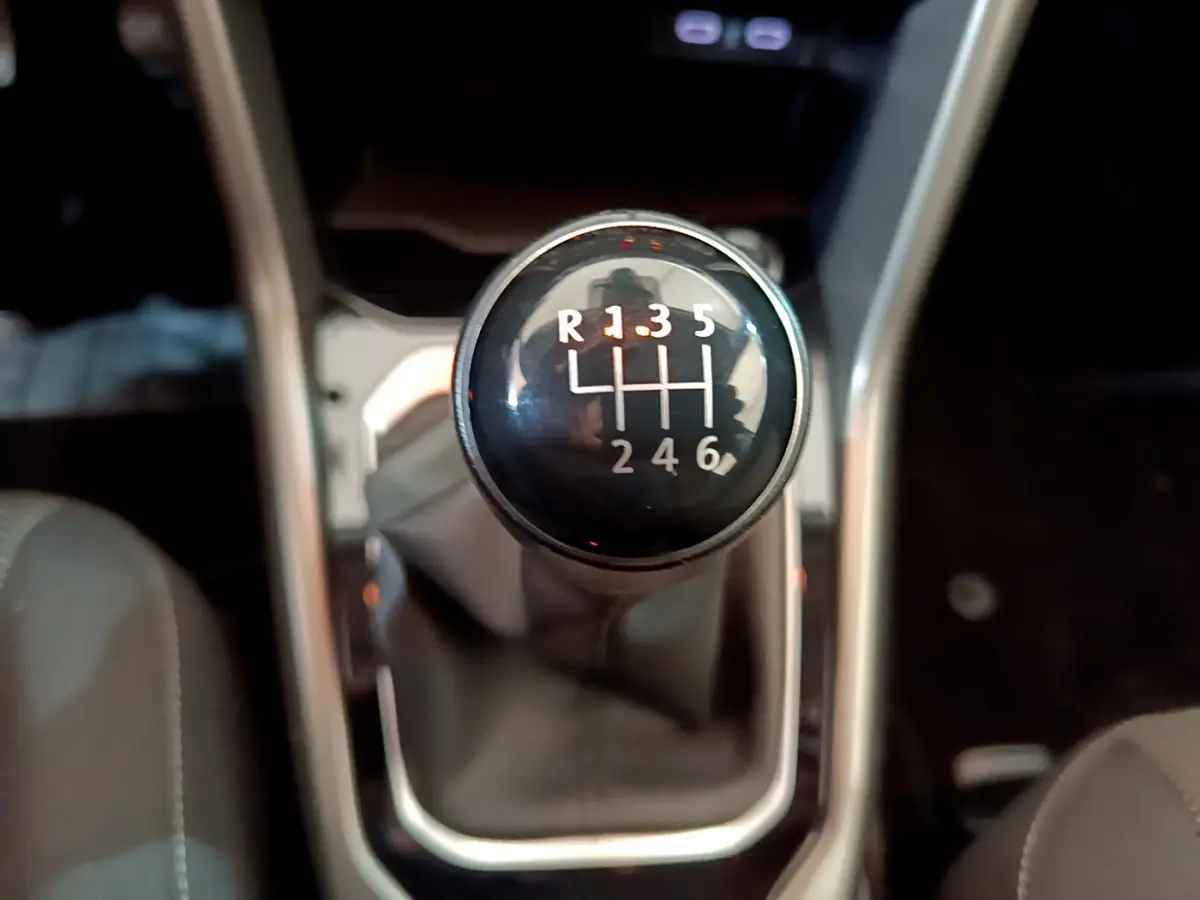 Gros plan sur le levier de vitesses manuel noir du Volkswagen T-Roc gris foncé, version 1.0 TSI 110 Lounge.