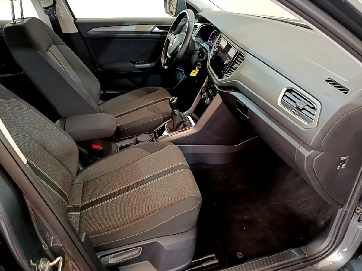 Vue intérieure côté passager du Volkswagen T-Roc 1.0 TSI 110 Lounge 2021 avec sièges tissu gris et tableau de bord moderne.