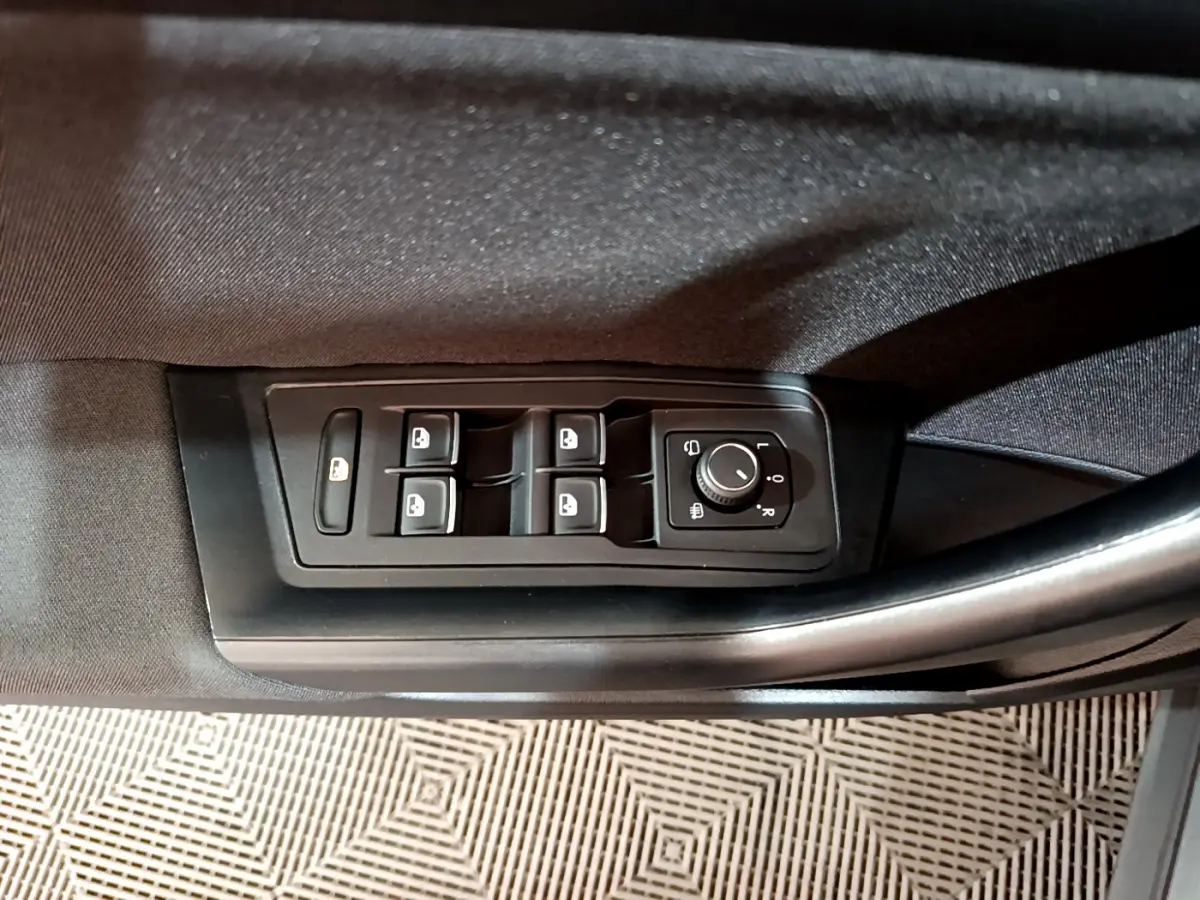 Gros plan sur les commandes des vitres et rétroviseurs côté conducteur d'un Volkswagen T-Roc gris foncé 2021.