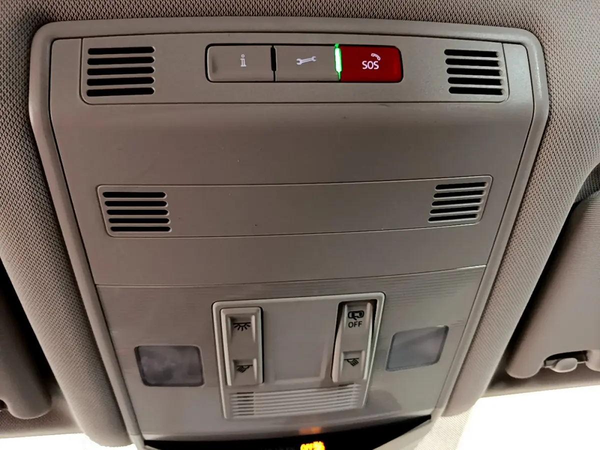 Vue en gros plan du panneau de commande de toit gris clair avec bouton SOS illuminé dans un Volkswagen T-Roc 2021.