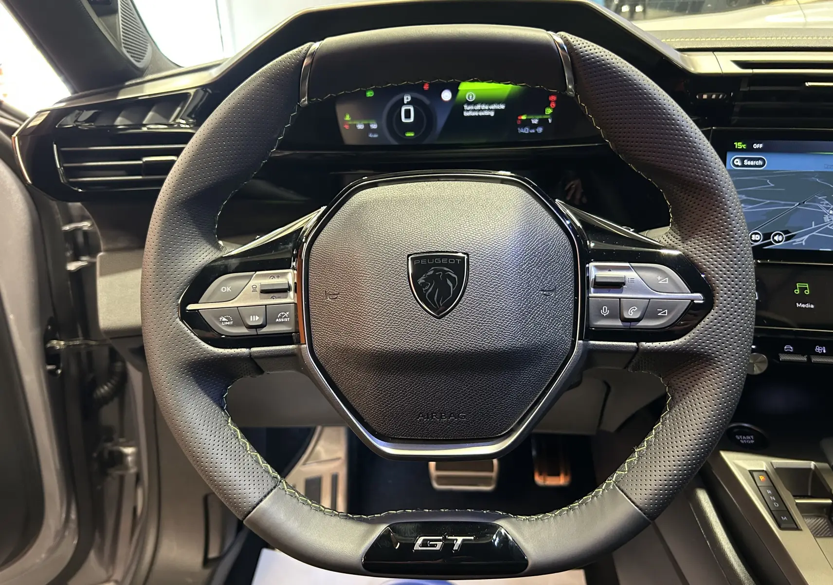 Vue centrée sur le volant GT de la Peugeot 308 III Ph.2, avec tableau de bord numérique et écran tactile visible.