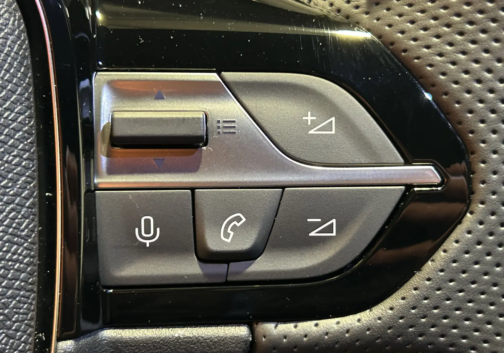 Gros plan sur les commandes noires du volant côté gauche de la Peugeot 308 GT gris Artense, boutons volume et appel.