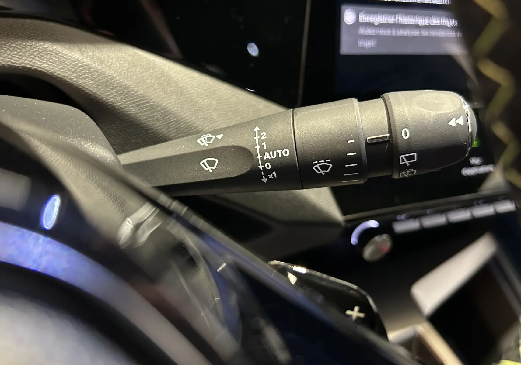 Gros plan sur la commande d’essuie-glace côté droit dans l’habitacle du Peugeot 308 gris Artense, version 2026.