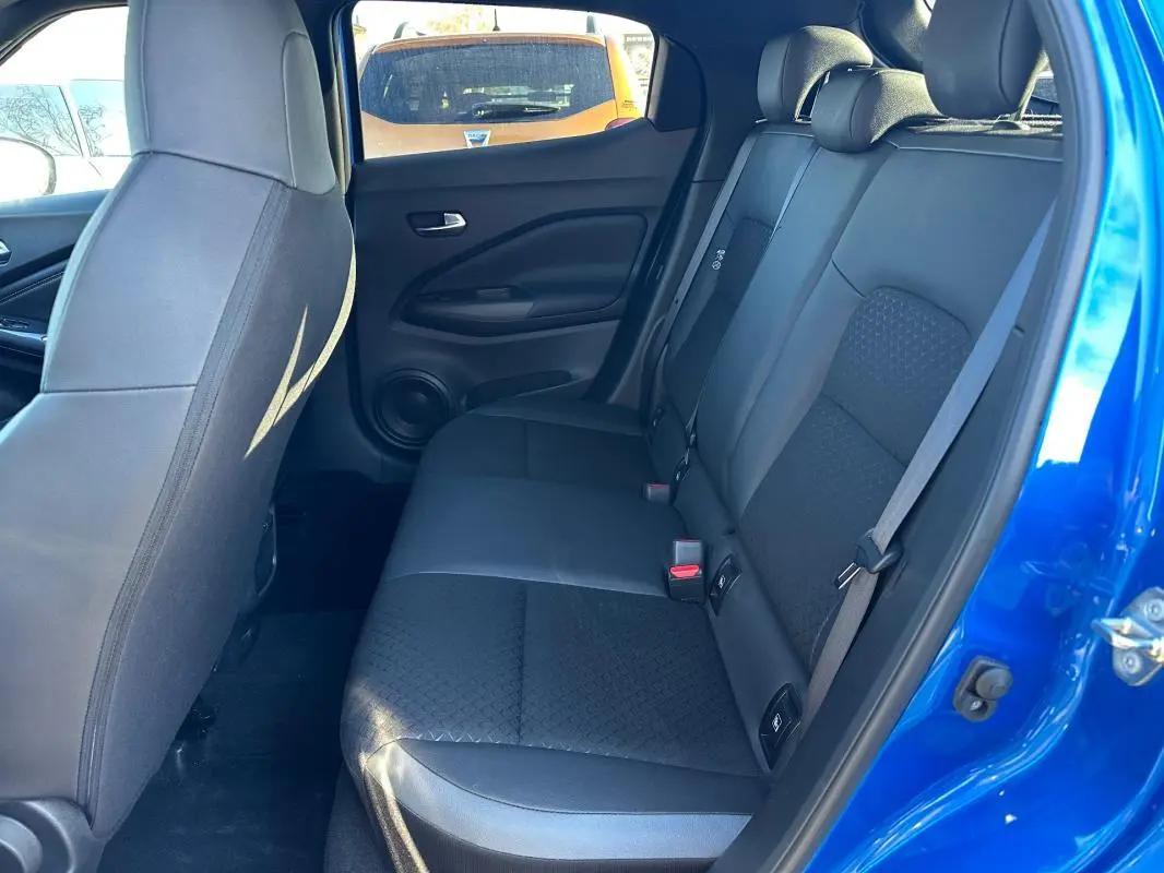 Vue intérieure côté droit des sièges arrière noirs du Nissan Juke 2023.5 bleu clair avec habillage tissu et cuir.