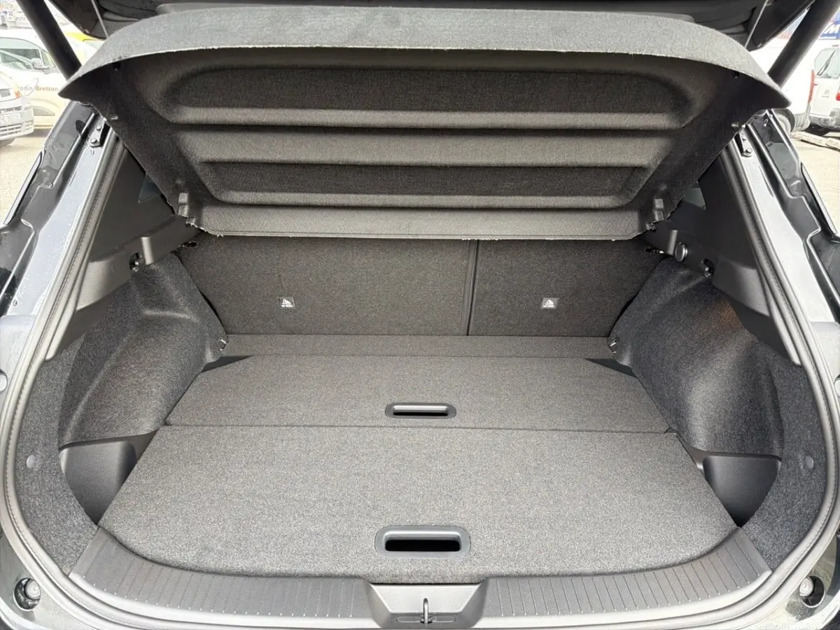 Coffre ouvert vu de l'arrière d'un Nissan Qashqai 1.5 e-Power noir, avec banquette rabattue et espace de chargement plat.