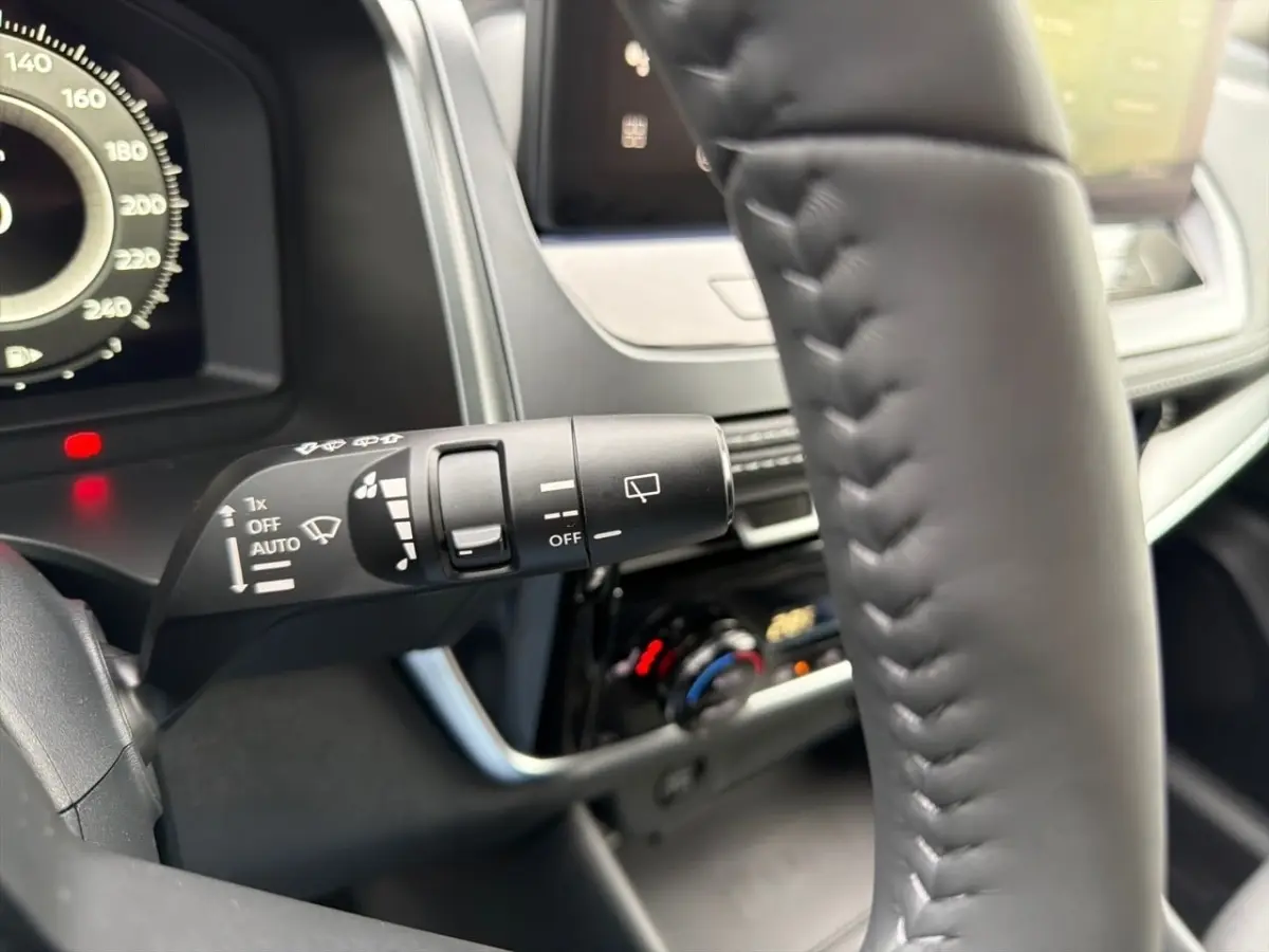 Gros plan sur le commodo d'essuie-glace à gauche du volant cuir noir du Nissan Qashqai 1.5 e-Power 2025.