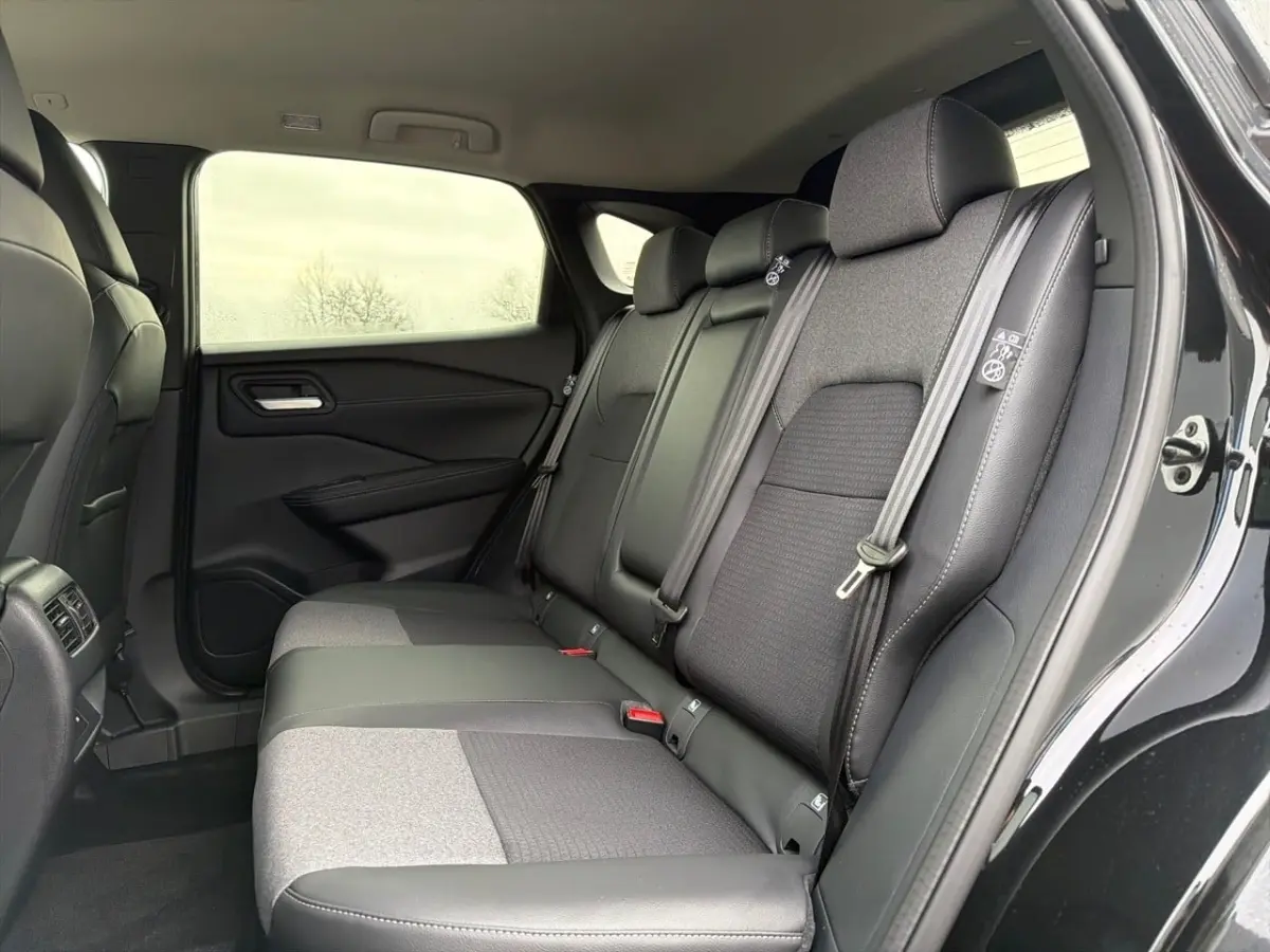 Vue intérieure côté droit sur la banquette arrière noire et grise du Nissan Qashqai 1.5 e-Power 2025 avec portières ouvertes.