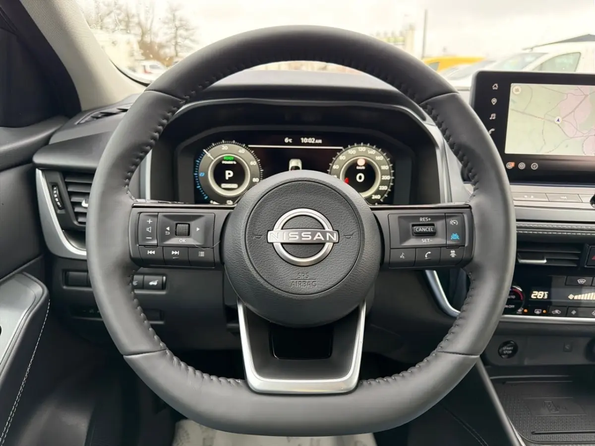 Vue frontale du volant cuir noir du Nissan Qashqai 1.5 e-Power avec tableau de bord numérique et écran tactile GPS.