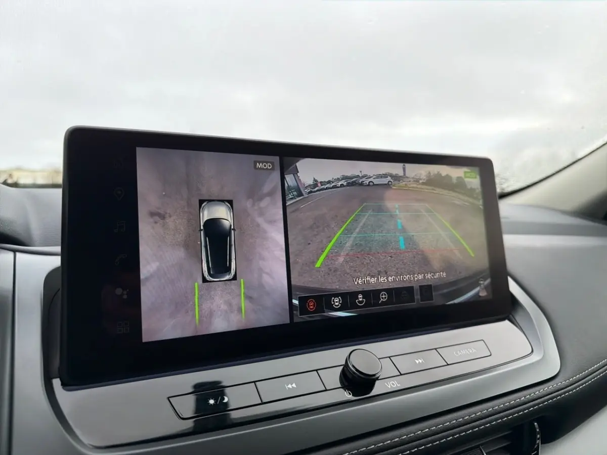 Écran tactile intérieur du Nissan Qashqai noir 2025 montrant la caméra 360° et l’aide au stationnement en vue arrière.