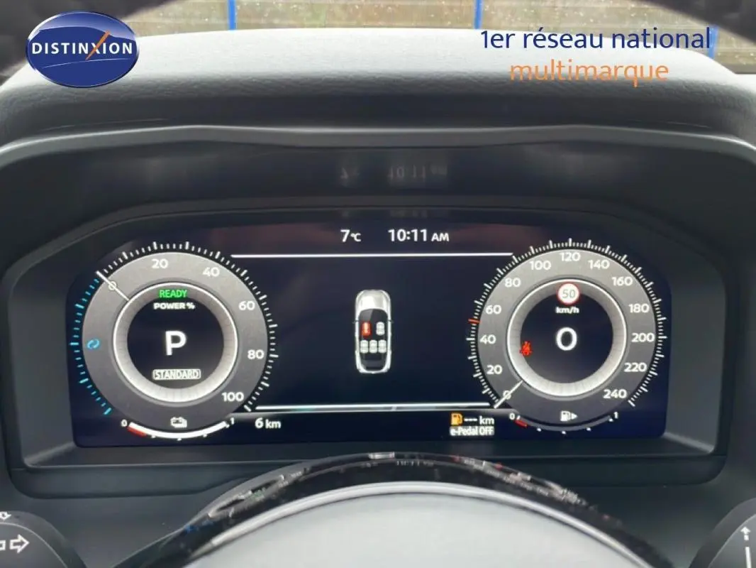 Vue frontale du cockpit numérique du Nissan Qashqai blanc 2025, affichant la vitesse et l'état du véhicule.