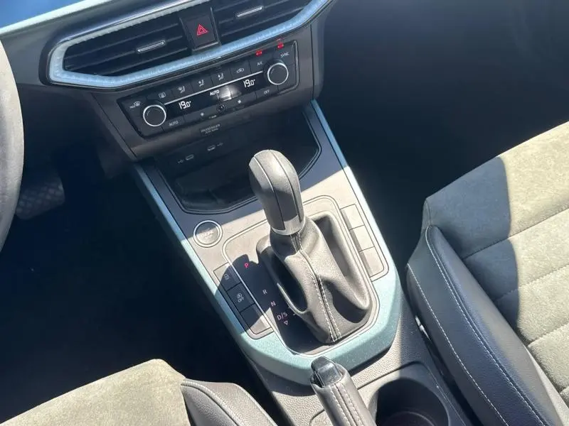 Vue rapprochée de la console centrale du SEAT Arona 2025 avec levier de boîte auto et sellerie tissu gris.