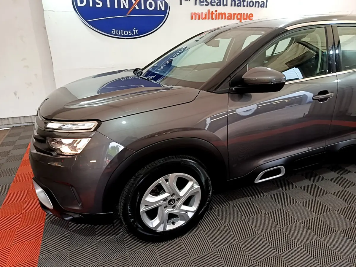 Vue 3/4 avant droit d'un Citroën C5 Aircross gris foncé avec jantes alliage et inserts Silver Anodisé sur les Airbump.