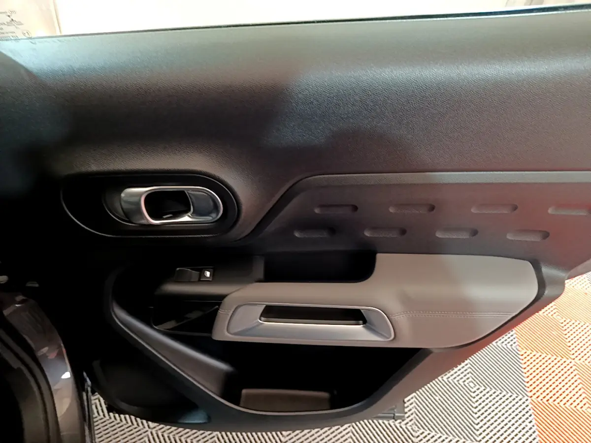 Gros plan sur la porte côté gauche intérieure du Citroën C5 Aircross 2020 avec poignée argent et garniture noire et grise.