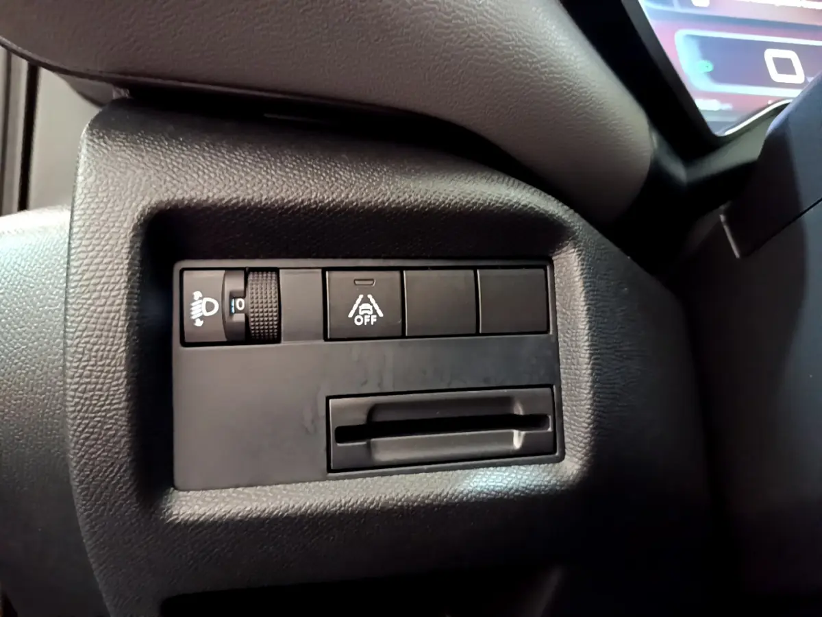 Gros plan sur les commandes d'assistance et réglage des phares à gauche du tableau de bord du Citroën C5 Aircross gris foncé 2020.