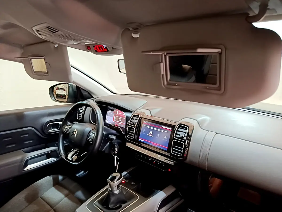 Intérieur du Citroën C5 Aircross 2020 vu côté conducteur, tableau de bord gris clair avec écran tactile et volant cuir noir.