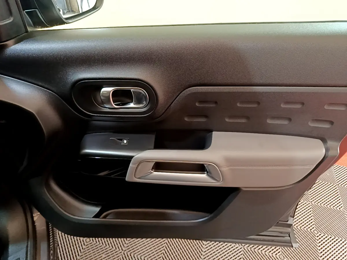 Gros plan sur la porte intérieure côté gauche du Citroën C5 Aircross 2020 avec accoudoir gris clair et poignée chromée.