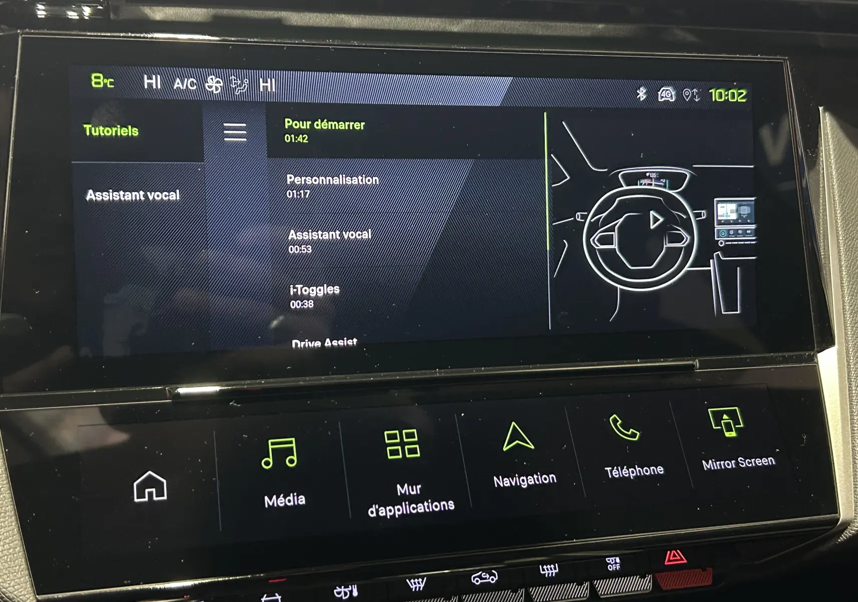 Écran tactile central du Peugeot 308 gris Selenium, affichant le menu tutoriels avec interface numérique moderne.