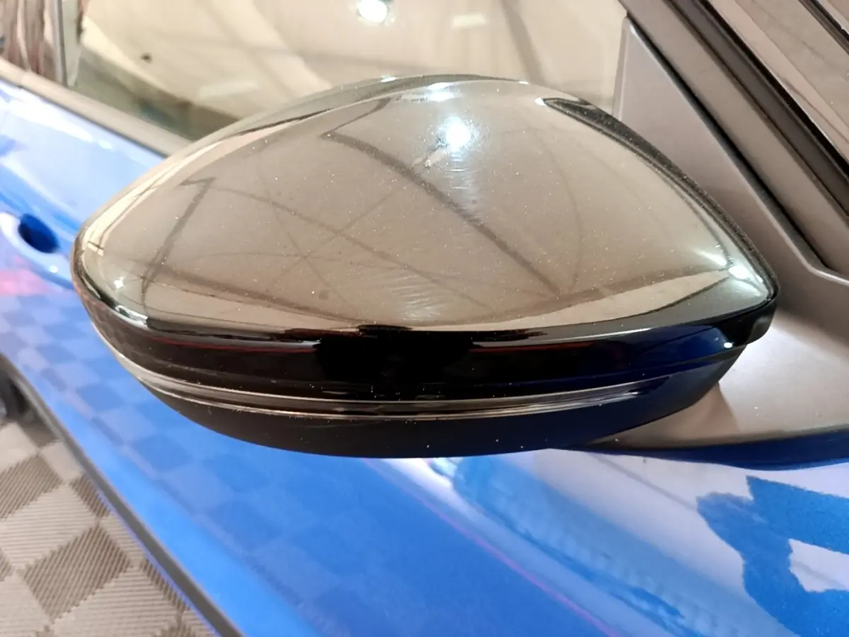 Rétroviseur noir côté gauche de l’Opel Mokka bleu 2024, avec clignotant intégré visible en extérieur.